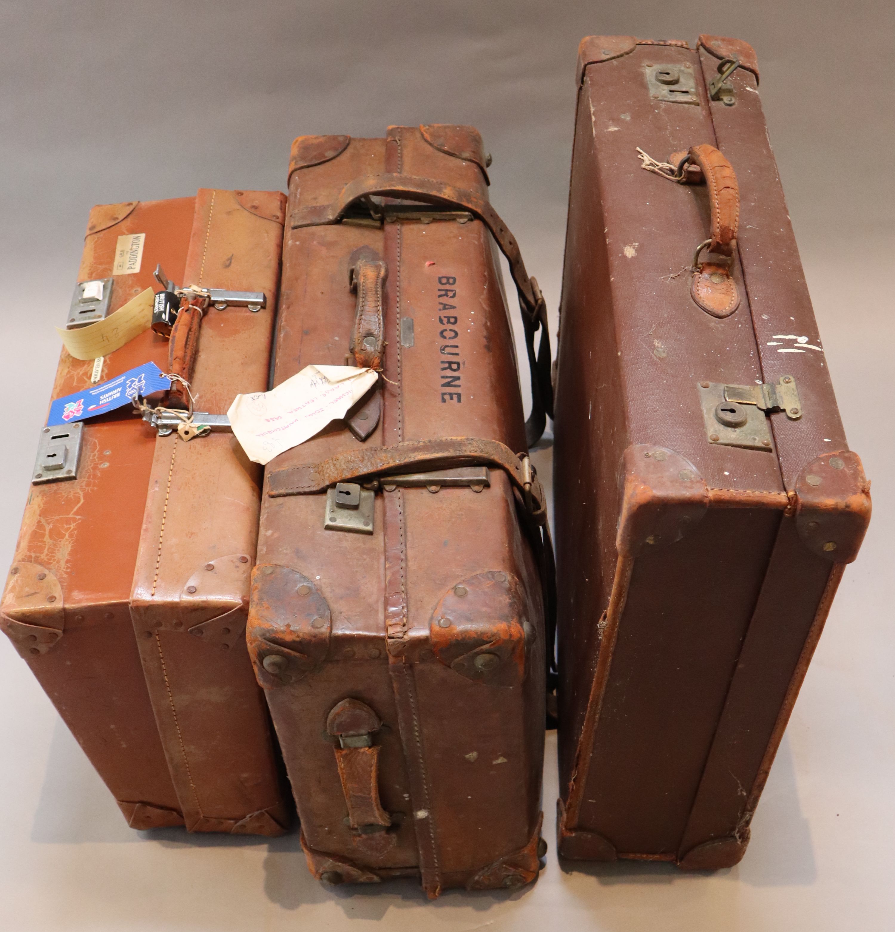 A group of three tan leather suitcases, one inscribed Brabourne, another Marchioness of Sligo